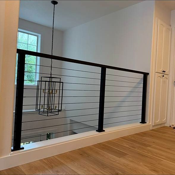 Horizontal rod railing along a landing beside a window