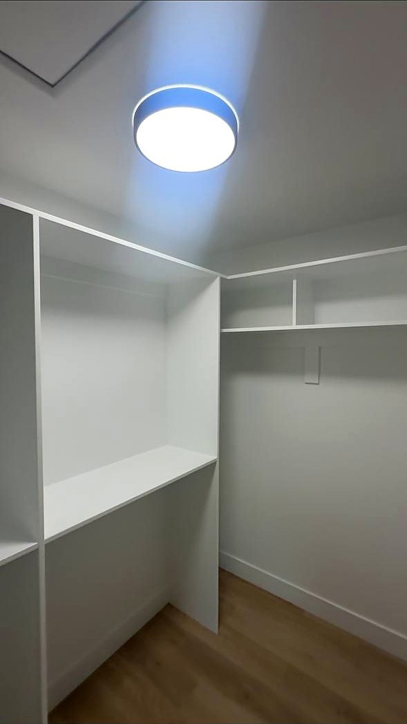 White walk-in closet with shelving and hanging rods
